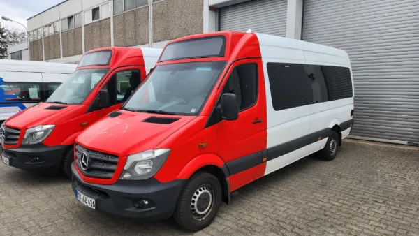 Zwei rot-weiße Kleinbusse für Behindertentransport Berlin, enger mobiler Bildausschnitt